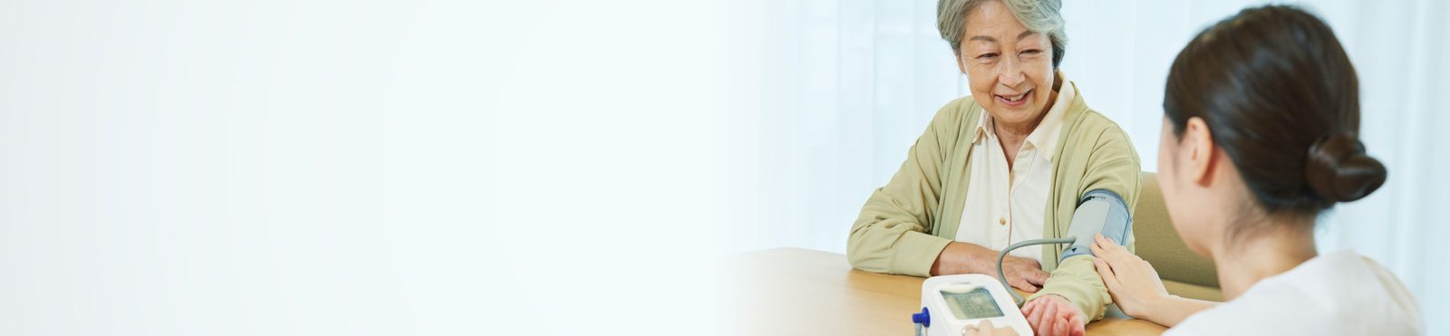 看護師が入居者の血圧を測るようす