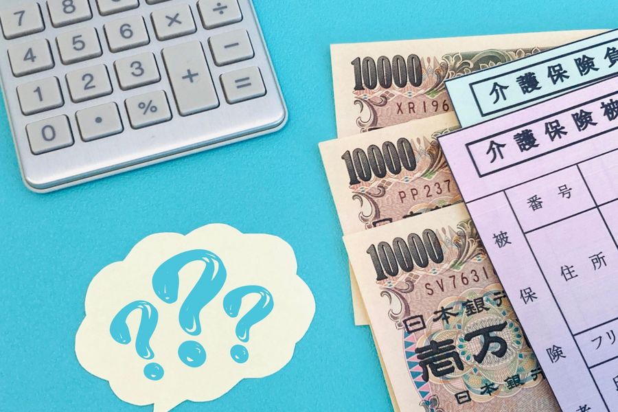介護保険の書類と、電卓、吹き出しの形のメモ