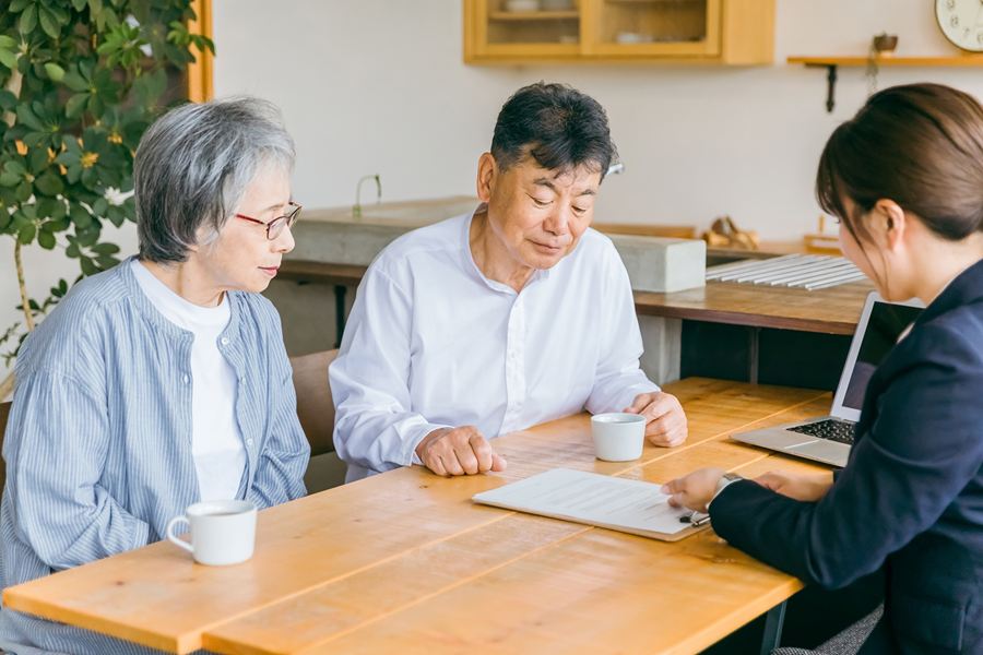 書類を見ながら、相談員の説明を聞く高齢の夫婦