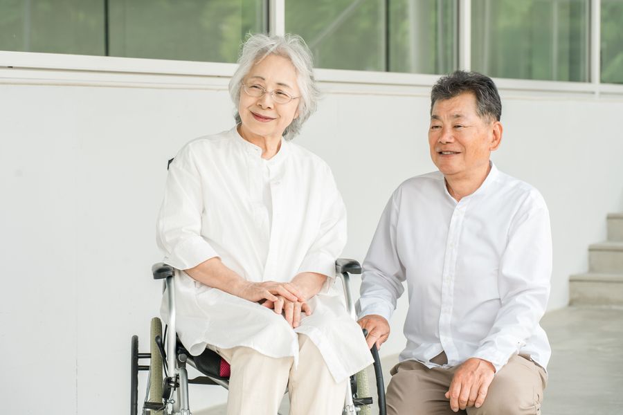 車いすの高齢の女性と、となりに座って笑顔で話す男性