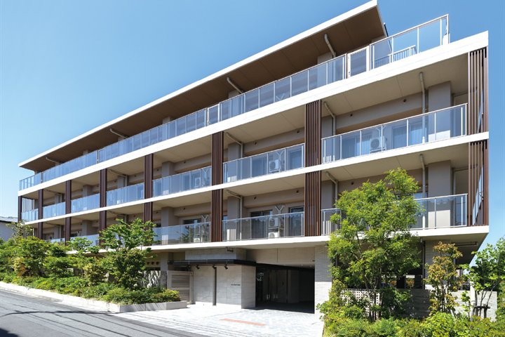 植栽に囲まれた4階建ての、東急ウェリナケア尾山台の外観