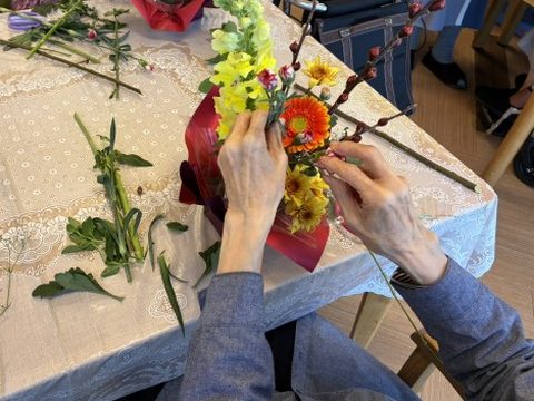 季節の花でアレンジメントをつくるご入居者の手元