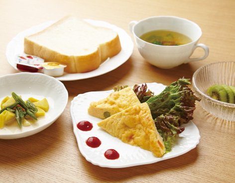 洋食の朝食の一例。食パンとオムレツ、温野菜、スープ、フルーツ