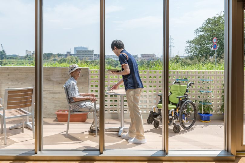 テラスで過ごすご入居者とスタッフ